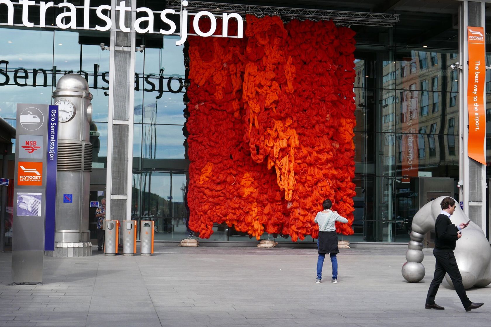 Oslo Sentralstasjon med en stor, rød kunstvegg