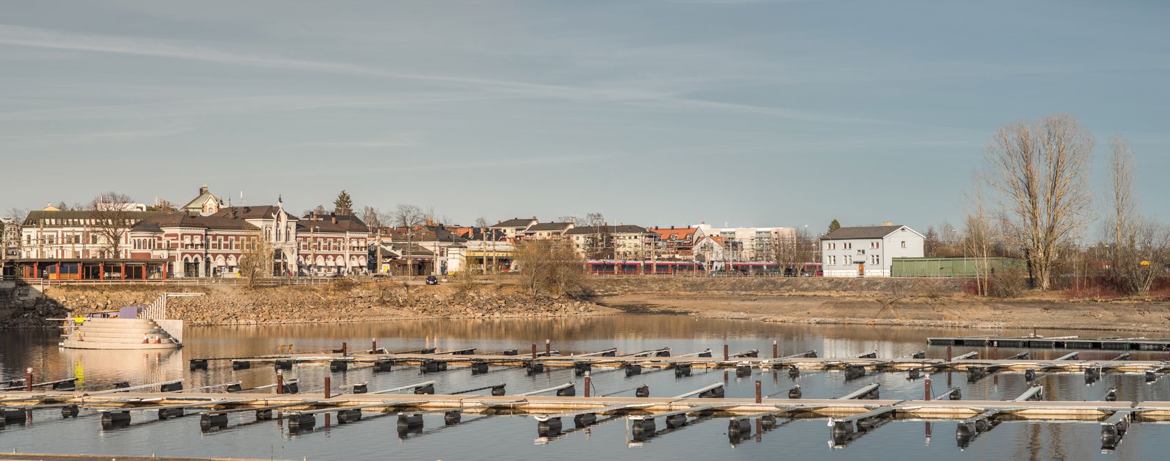 Brygge og vann, med stasjonen i bakgrunnen