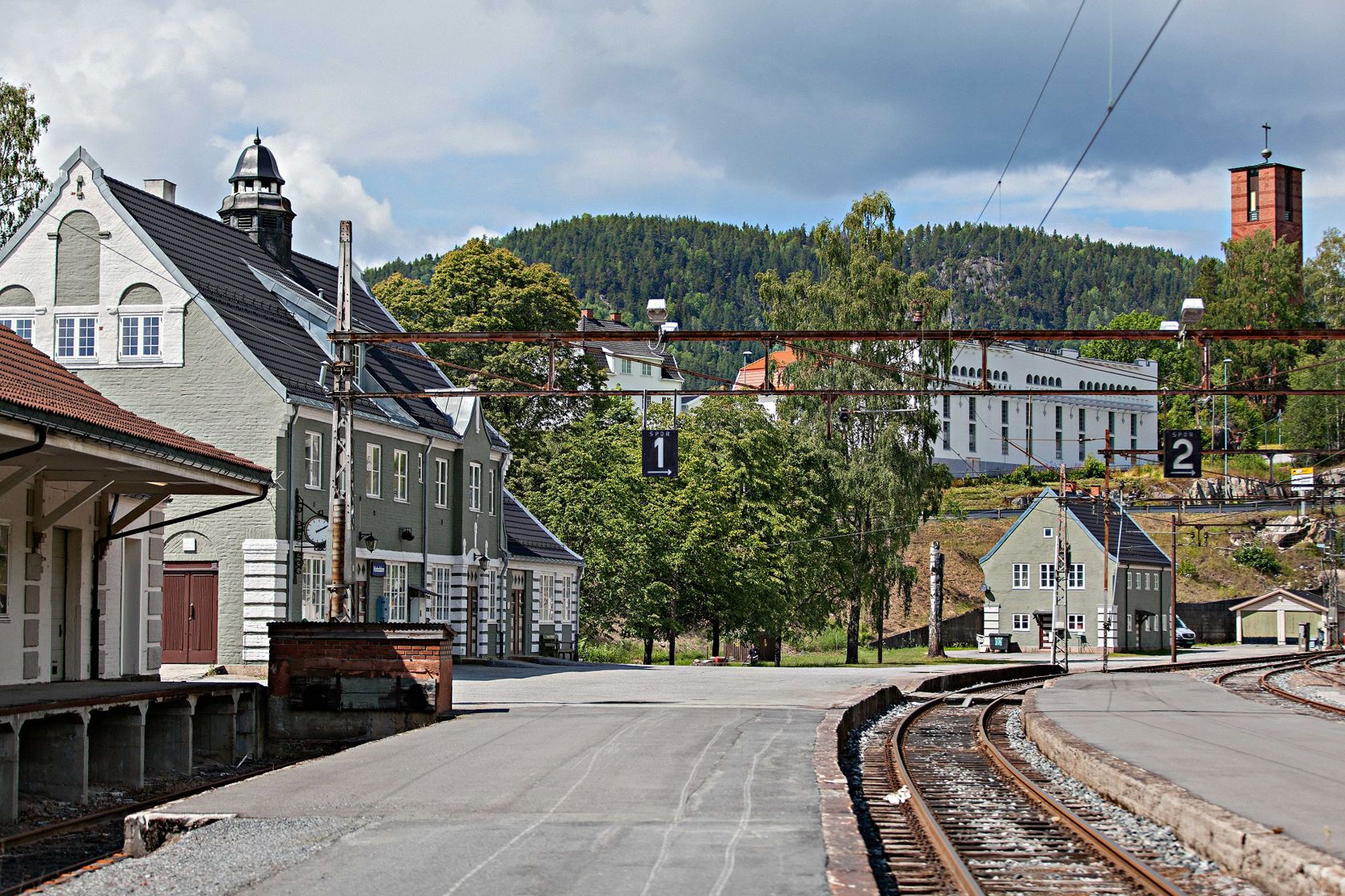 jernbaneplattform og stasjon i mur på sommerstid