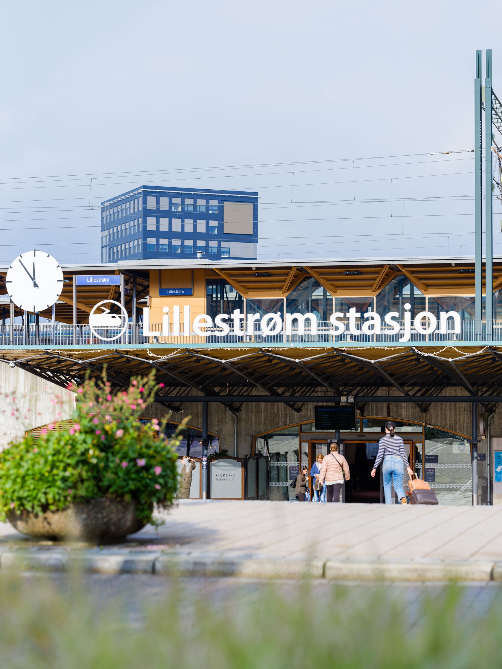 Inngangen til Lillestrøm stasjon. Mennesker går til stasjonen.